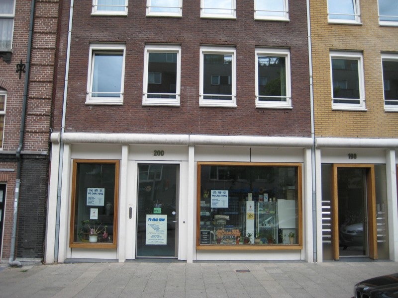 Gevel en ingang van Praktijk Po Chai Tong aan de Valkenburgerstraat 200 in Amsterdam